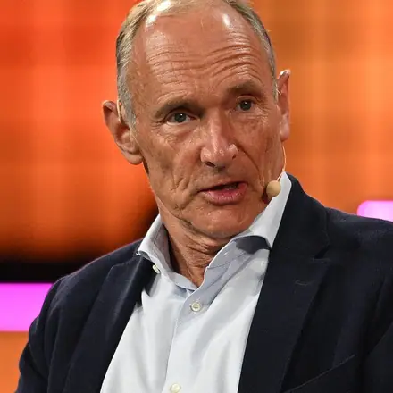 Photographie de Tim Berners-Lee s'exprimant lors d'une conférence, micro-casque au visage