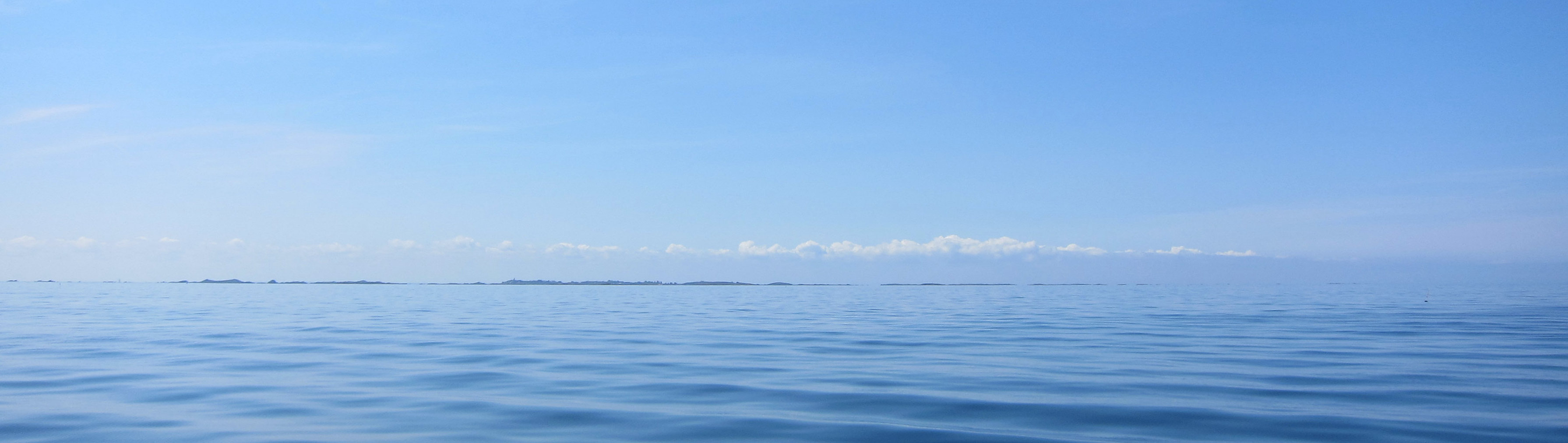 vue de l'archipel de Chausey en Normandie qui affleure à l'horizon sur une mer calme